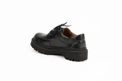 Zapato acordonado de cuero negro con suela track.