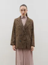 Blazer de lana con diseño cruzado y doble botonadura frontal. Presenta solapas clásicas, corte holgado y textura jaspeada en tonos marrones.