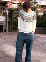 Sweater tejido a mano en hilo de algodón color crudo, con diseño geométrico en colores azul, rojo, verde y marrón en la parte superior.