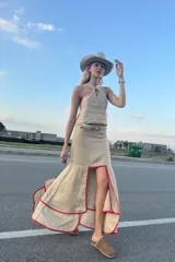 Top color beige confeccionado en lino con escote halter y reborde rojo.