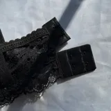 Conjunto de lencería de encaje compuesto por un soutiene con aro y detalles de moños pequeños en el centro.