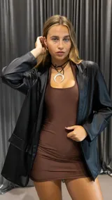 Blazer negro de eco cuero, con solapas de muesca, corte recto y bolsillos delanteros con solapa.