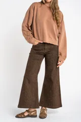 Buzo lila oversize confeccionado en 100% algodón, con cuello redondo, mangas largas y puños y dobladillo acanalados. Presenta un pequeño detalle bordado en el bajo.