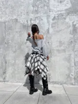 Bota tipo biker de caña alta, confeccionada en cuero sintético negro, con suela track y múltiples hebillas metálicas ajustables a lo largo de la caña.