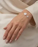 Pulsera de plata italiana 925 con cadena de eslabones finos, presenta dos dijes circulares, uno con incrustación de nácar y centro de circonia, y otro pequeño con pavé de circonias. Incluye cadena de alargue con dije final en forma de corazón.