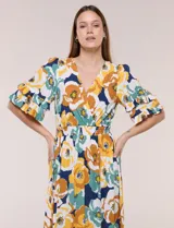 Vestido midi de calce holgado y caída fluida con escote en V cruzado, cintura elastizada fruncida y mangas cortas con volados superpuestos. Cuenta con un diseño estampado de flores grandes en tonos amarillo, blanco, azul marino y verde.