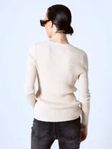 Cardigan de punto fino color beige, con escote en V y cierre frontal con botones.