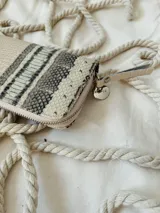 Billetera grande de cuero con cierre metálico perimetral. Presenta un diseño combinado con una sección superior de textura tipo piel de serpiente y una sección inferior con textura grabada tipo cocodrilo en color beige.