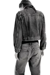 Jean de tiro alto con corte wide leg y diseño de cinco bolsillos. Presenta un acabado en denim azul con detalles de roturas desgastadas en la parte frontal.