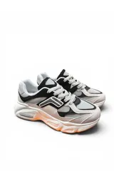 Championes deportivos en combinación de gris y beige, con diseño chunky de suela gruesa texturizada con detalles en tono anaranjado, cordones blancos y detalles laterales en relieve.