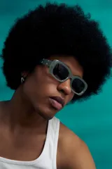 Lentes de sol rectangulares negros con protección UV y apliques metálicos en las patillas.