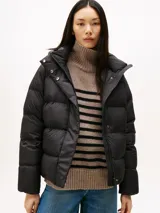 Campera acolchada tipo puffer de Tommy Hilfiger, color negro, con relleno de plumón, capucha fija, cierre frontal con cremallera oculta y botones a presión, y logo tonal bordado en el pecho.