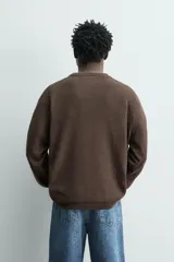 Jersey relaxed fit de punto en hilatura con mezcla de algodón y cashmere. Presenta cuello redondo con cierre frontal de botonadura y manga larga.