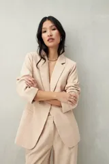 Blazer color crema a rayas verticales finas, de corte recto y solapas clásicas.