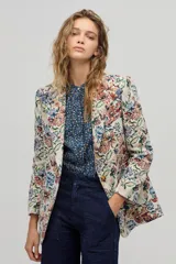 Blazer de poliéster con estampado floral, corte boxy, bolsillos frontales y cierre de un botón. Las mangas largas tienen un forro de algodón a rayas que se puede lucir al doblarlas.