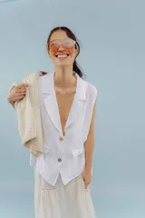 Chaleco color amarillo pastel de lino, sin mangas, con cuello solapa y cierre frontal con dos botones.