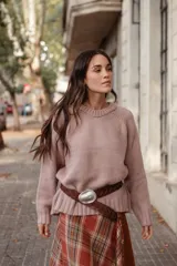 Buzo de lana color rosado, con cuello redondo, mangas largas y diseño holgado.