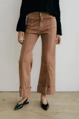 Jean de mezclilla azul oscuro con costuras contrastantes marcadas en el frente y dobladillo ancho vuelto en el ruedo.