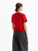 Remera de jersey pesado color blanco, con cuello redondo en contraste negro y estampa central de un corazón con diseño animal print atravesado por una flecha.