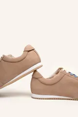 Zapatilla de gamuza color bordó con cordones bicolores, interior de cuero vacuno y suela de caucho blanca y beige.