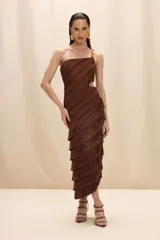 Vestido midi de un solo hombro en color marrón, confeccionado en tejido de punto con textura acanalada. Presenta un diseño con cut-out lateral en la cintura y una falda con múltiples capas de flecos que aportan movimiento.