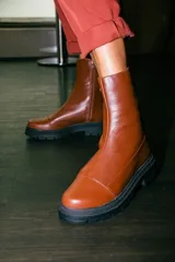 Borcegos de cuero negro con caña media, cierre lateral interno y suela track de goma con plataforma de 4,5 cm.