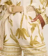 Short de cintura alta con estampado de cocoteros y elementos étnicos, trabillas en la cintura, cierre tradicional, pliegues y bolsillos falsos atrás. Incluye cinturón de rafia artificial con hebillas de argollas.