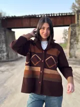 Campera marrón con diseño geométrico en tonos beige y marrón, con cuello tipo chal y cierre con botones.