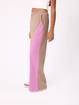 Babucha de corte holgado en color beige con paneles laterales en color fucsia y vivos blancos. Presenta cintura elástica y logo bordado en la parte superior.