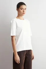 Remera de corte oversized, color verde oliva, con cuello redondo y mangas cortas.