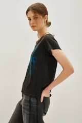 Remera de algodón color negro con efecto lavado, de corte clásico y manga corta. Presenta un estampado frontal con la palabra 'COSMIC' en el centro rodeada por la palabra 'DANCE' repetida en tonos degradados de verde a azul.