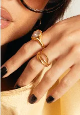 Anillo de diseño orgánico y ajustable, elaborado en acero quirúrgico con acabado dorado. Presenta una estructura de líneas fluidas y entrelazadas que envuelven el dedo.