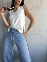 Musculosa tejida color crema con escote en V y botones laterales.