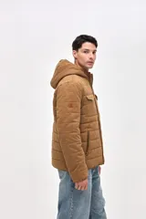 Campera de gabardina capitoneada con interior forrado en nylon. Presenta capucha fija, bolsillos frontales en el pecho con solapa y bolsillos laterales con cierre. Cuenta con cierre frontal central.