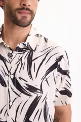 Camisa de viscosa de manga corta con corte clásico, fondo blanco y estampado abstracto en color negro.
