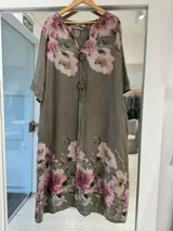 Vestido midi color visón con estampa floral en tonos rosados y verdes, escote en V con cordones y botones decorativos de madera en el centro, y mangas cortas.