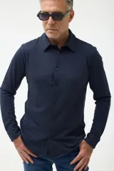 Camisa azul marino de piqué con cuello clásico, manga larga y cierre frontal con botones.