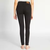 Pantalón de jean negro, corte skinny, tiro alto y cierre frontal con cuatro botones.