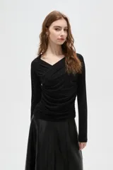 Top de manga larga color negro, confeccionado en poliéster, con diseño drapeado frontal y cuello en V.