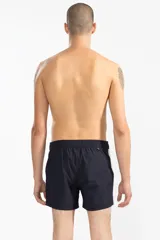 Short de baño azul marino con tira lateral blanca estilo tuxedo, cintura elástica con cordón regulable, dos bolsillos laterales y uno trasero con cierre.