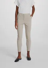 Pantalón de sastre negro de corte ajustado y tobillero, de tiro alto con cierre frontal.