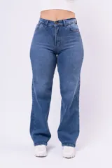 Pantalón de jean estilo wide leg, de tiro alto, con corte recto y piernas anchas. Presenta un lavado azul medio clásico, con costuras en tono ocre y cierre frontal con botón metálico.