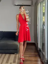 Vestido corto rojo con escote halter, espalda descubierta y falda acampanada.