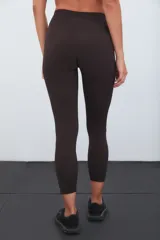 Calza deportiva de tiro alto color marrón, con diseño de perforaciones láser en la parte inferior de las piernas.