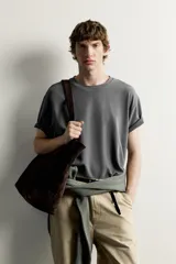 Remera de corte holgado color gris oscuro, con cuello redondo y mangas cortas. Confeccionada en tejido suave con mezcla de modal.