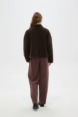 Tapado de textura tipo corderito en color marrón, con cuello solapa y cierre frontal de botones.