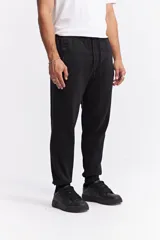 Pantalón de jogging color gris melange, confeccionado en tejido de algodón y poliéster. Presenta cintura elástica con cordón de ajuste, bolsillos laterales con cierre y puños elásticos en los tobillos.
