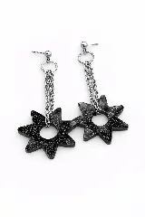 Par de caravanas colgantes con base de esfera metálica y aro, de donde cuelgan cadenas de eslabones y un dije en forma de estrella de seis puntas color negro con brillo.