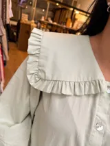 Camisa verde menta con amplio cuello marinero con volados, mangas largas y abotonadura frontal con botones nacarados.