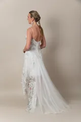 Vestido blanco irregular de tul bordado en hilo color plata y blanco, con breteles finos.